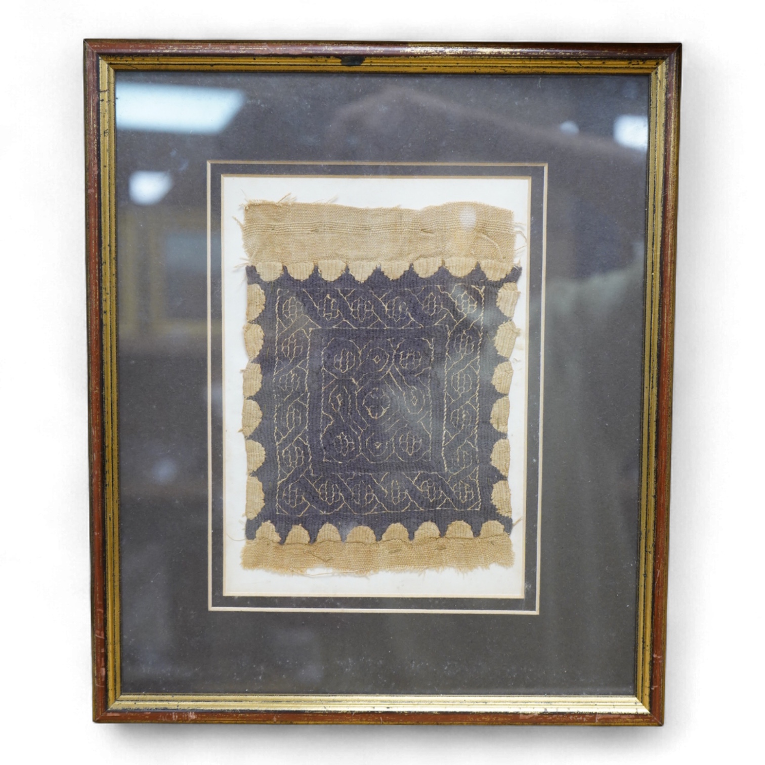 A framed Coptic textile fragment, probably Egyptian, circa 7th century A.D. (Please see notes on reverse), 16cm x 12cm. Condition - good